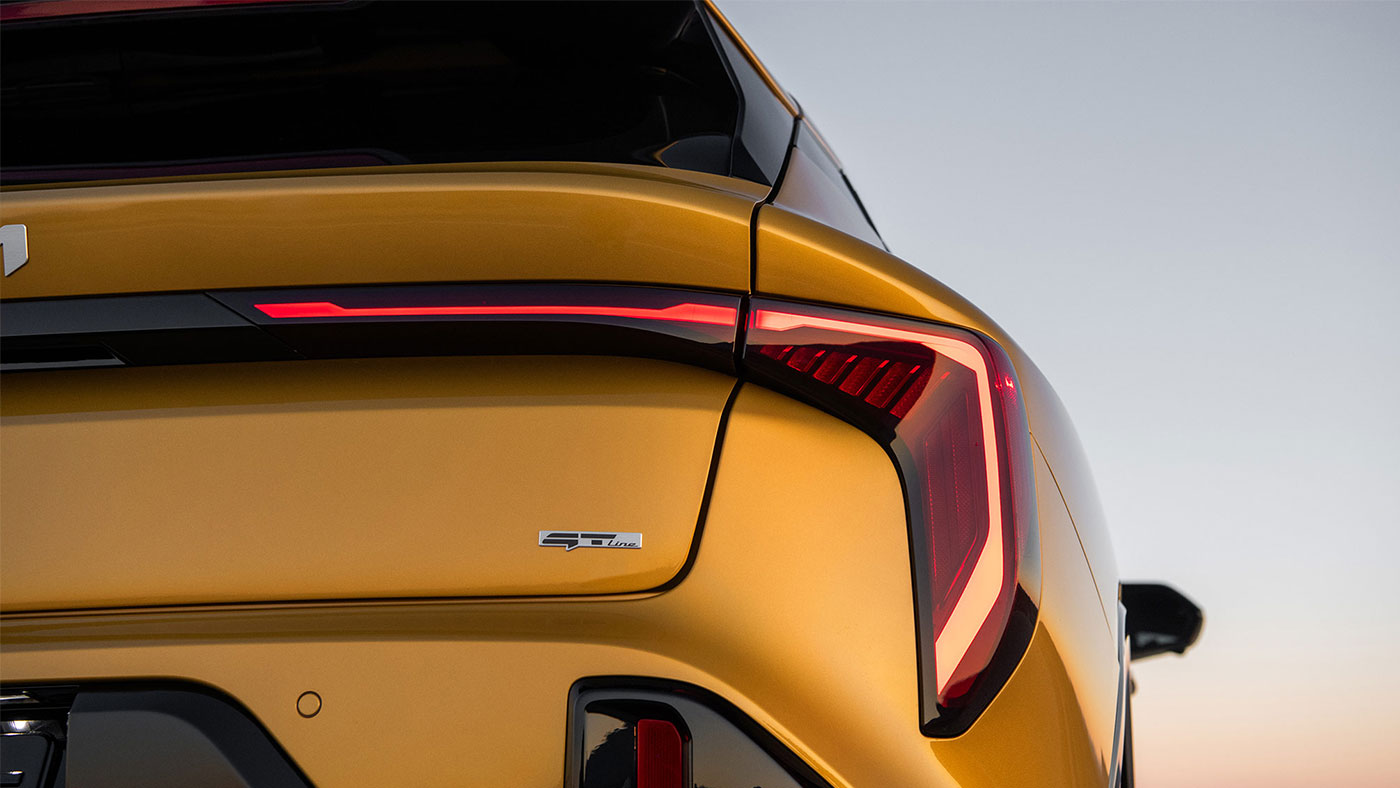 A close up of the 2026 Kia K4 Hatchback from behind, showing off one of its angular LED taillights and exclusive GT bading