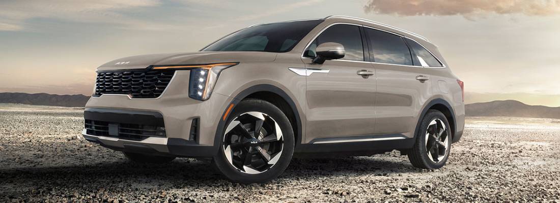 The 2026 Kia Sorento PHEV in pale brown parks on dirt track in front of a pale sky