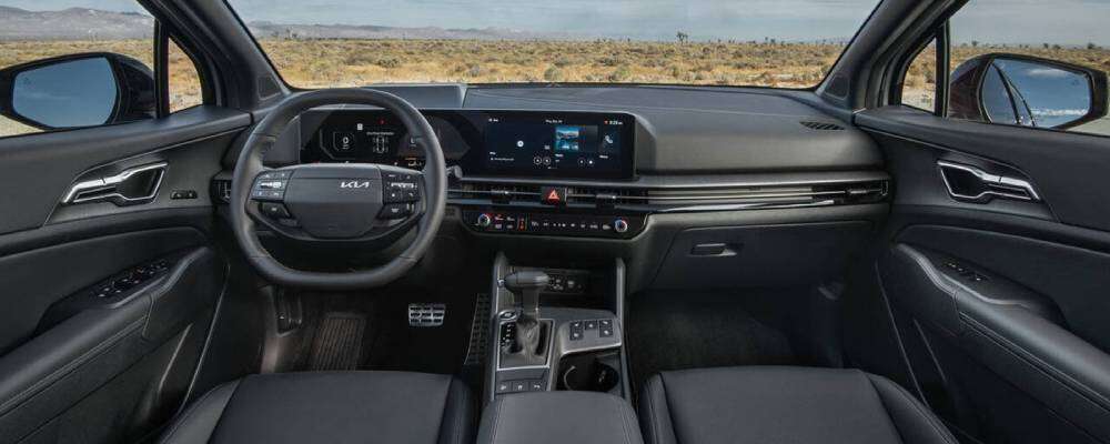 Dashboard of the 2026 Kia Sportage featuring steering wheel and touchscreen. 2026 Kia Sportage interior cabin amenities at Lally Kia